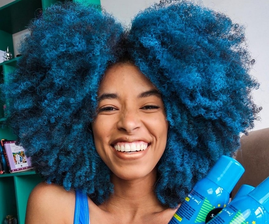jovem negra com cabelos cacheados na cor azul