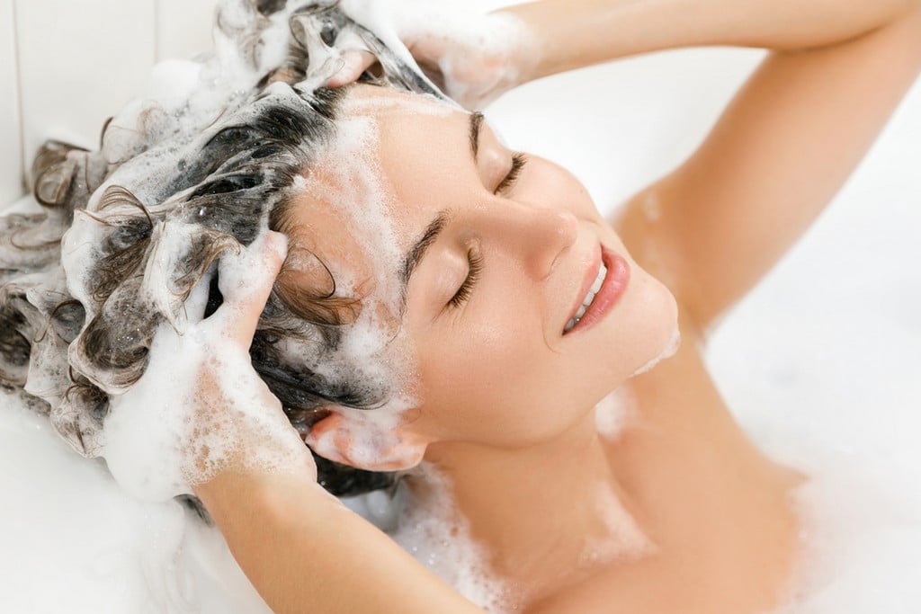 Mulher lavando o próprio cabelo