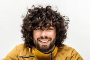 Homem com cabelo ondulado, com corte repicado com franja desconectada