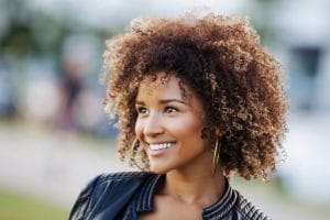 Mulher de cabelo cacheado com corte assimétrico